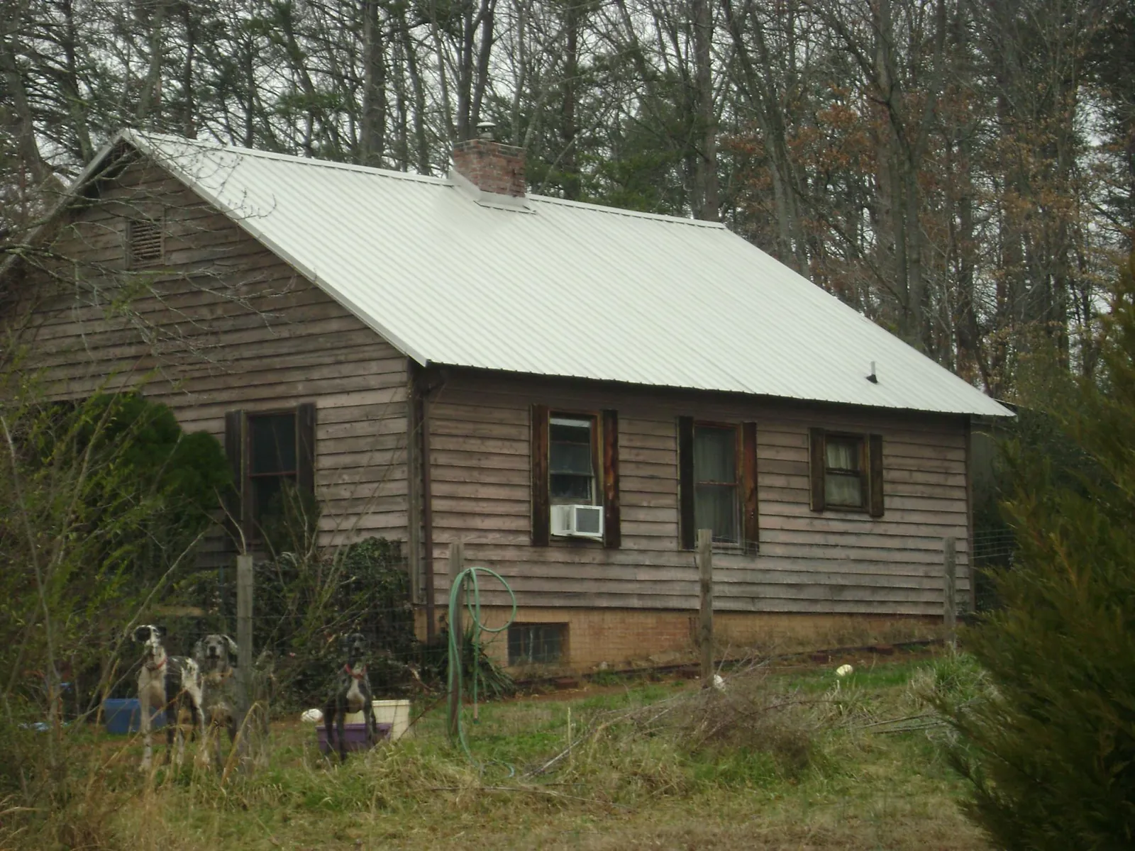 White metal roof on an old wood sided farmhouse, from a Metal Roof Installation job in Toluca